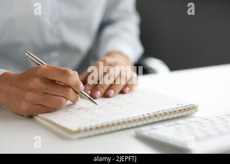 Planification d'entreprise et femme d'affaires travaillant et vérifiant le calendrier sur le lieu de travail Banque D'Images