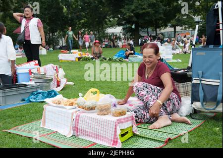 Berlin, Allemagne. La communauté des Thaises immigrés dans le quartier Wilmersdorf (Viertel) fabriquent, produisent, cuisinent et vendent leur cuisine asiatique et Tai à chaque fois que vous sarclez à l'intérieur du Preußenpark (Preussenpark). En plus de cela, quelques centaines de Berlinois visitent le parc simultanément pour avoir leur Sunday Picknick, souvent complété par de la nourriture achetée aux migrants Tai. Banque D'Images