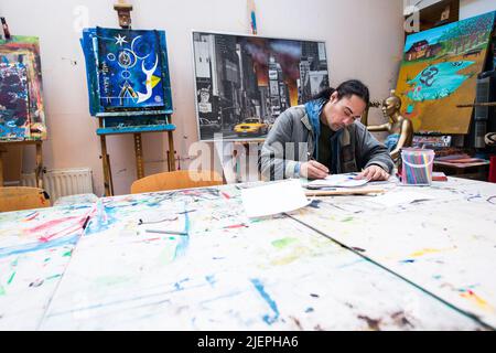 Rotterdam, pays-Bas. Un client de réinsertion masculin de via Kunst projet de Pauluskerk travaillant sur une table de studio d'art sur la création d'une nouvelle œuvre d'art et d'art, qui peut être vendu dans le magasin d'avant et boutique d'art en bas ville. Banque D'Images