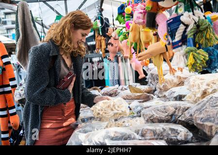 Tilburg, pays-Bas. Jeune adulte, une étudiante en art achète ses courses hebdomadaires au marché hebdomadaire du samedi. En raison de diverses situations de crise en Europe (par exemple, la crise énergétique due à l'invasion russe en Ukraine), les prix augmentent de pourcentages à deux chiffres, entraînant une énorme inflation pour les ménages communs. Banque D'Images