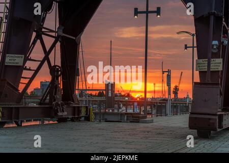 Des grues historiques sur les boulevards au bord de la rivière à Szczecin pendant un lever de soleil spectaculaire Banque D'Images