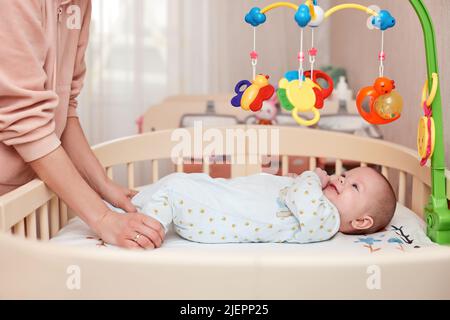 Massage de bébé. Mère faisant de la gymnastique avec l'enfant nouveau-né Banque D'Images