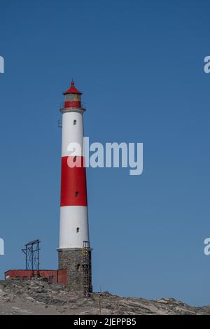 Un phare blanc et rouge devant un ciel bleu à la pointe Diaz près de Lüderitz en Namibie Banque D'Images