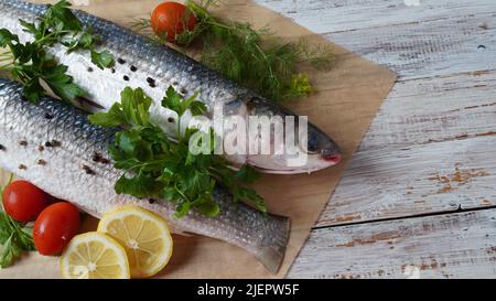 Fruits de mer poisson-mulet frais au citron vert, aux herbes et aux épices sur une vieille table en bois. Banque D'Images