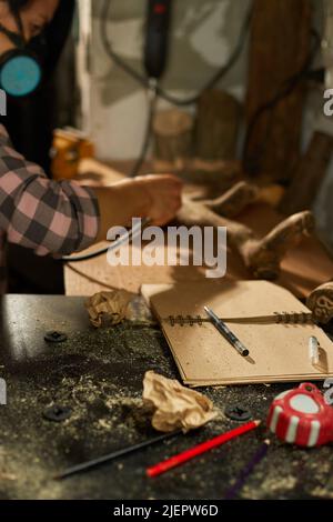 Femme utilisant des outils de travail de bois de puissance Graver, sculptant pendant la fabrication, créant des souvenirs artisanaux faits à la main, femme dans l'atelier. Banque D'Images