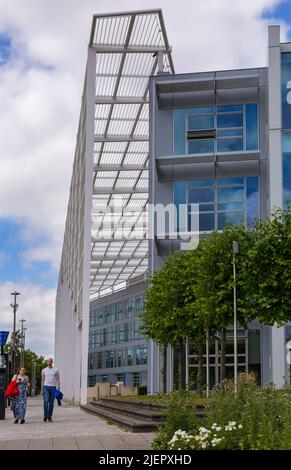 Couple passant devant le bâtiment du Quadrant à Milton Keynes, Buckinghamshire, Royaume-Uni en juin Banque D'Images