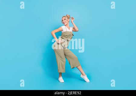 Photo de tout le corps de la femme blonde funky danse vêtements t-shirt ensemble baskets isolées sur fond bleu Banque D'Images