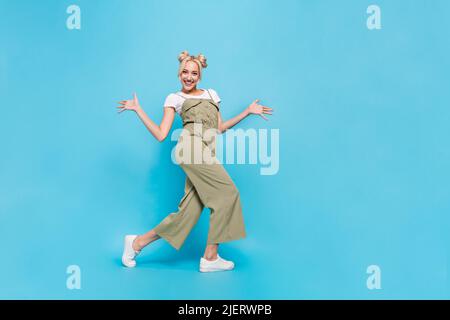 Photo pleine grandeur de belle blonde femme danse vêtements t-shirt ensemble baskets isolées sur fond bleu Banque D'Images