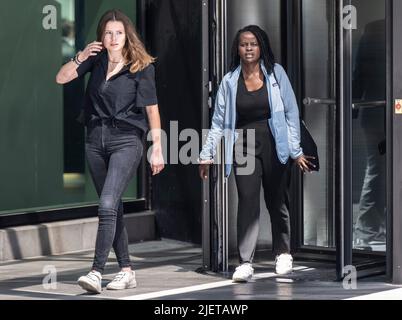 28 juin 2022, Hessen, Francfort-sur-le-main: L'activiste climatique allemand Luisa Neubauer (l) du mouvement climatique vendredi pour l'avenir quitte la Deutsche Bank avec l'activiste ougandais Evelyn Acham après des entretiens avec la direction de la société. Neubauer avait protesté auprès des activistes de l'environnement de l'Ouganda contre l'extraction des combustibles fossiles et la construction d'un pipeline en Afrique. Photo : Boris Roessler/dpa Banque D'Images