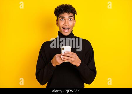 Photo de doux impressionné peau sombre gars habillé turtleneck chat périphérique moderne périphérique isolé couleur jaune arrière-plan Banque D'Images