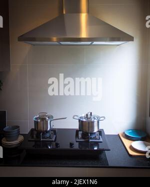 Pot de cuisson en acier inoxydable sur une cuisinière à gaz noir sur une cuisine Banque D'Images