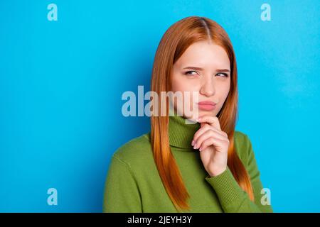 Photo de la jeune femme pensive look vide espace penser tenir main menton isolé sur fond bleu Banque D'Images