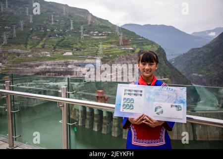 (220628) -- KUNMING, 28 juin 2022 (Xinhua) -- Une fille présente une collection de timbres sur le développement de l'hydroélectricité à la station hydroélectrique de Baihetan, qui chevauche les provinces du Yunnan et du Sichuan, dans le sud-ouest de la Chine, au 28 juin 2022. Mardi marque le premier anniversaire de l'exploitation des deux premières centrales de la centrale hydroélectrique de Baihetan, un projet majeur du programme de transport d'énergie de l'ouest-est de la Chine. La station a une capacité installée totale de 16 millions de kilowatts. La station hydroélectrique est située sur la rivière Jinsha, la partie supérieure du fleuve Yangtze, au sud-ouest Banque D'Images