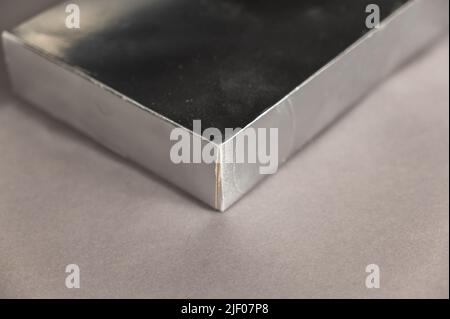 Une boîte rectangulaire argentée sur fond gris. Copier l'espace pour le texte et les éléments de conception. Mise au point sélective. Banque D'Images
