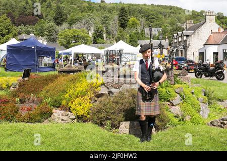 Un jeune homme jouant les cornemuses à Drumnadrochit Craft Fair and Market près du Loch Ness, en Écosse, au Royaume-Uni Banque D'Images