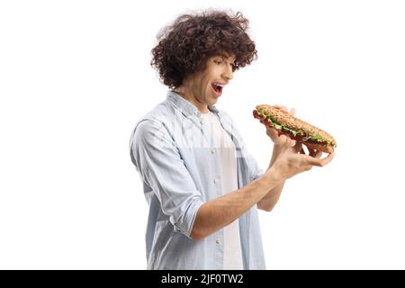 Jeune homme aux cheveux bouclés tenant un sandwich de baguette isolé sur fond blanc Banque D'Images