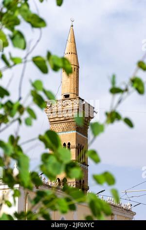 Vue à angle bas du minaret DE la mosquée EL Atik de la ville de Setif. Le célèbre monument de la ville. Feuilles vertes floues au premier plan. Banque D'Images