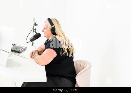 Femme portant un casque parlant dans le microphone du bureau Banque D'Images