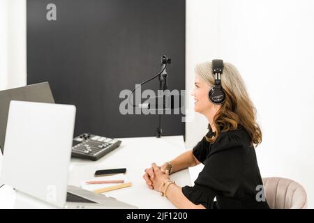 Femme portant un casque souriant devant le microphone Banque D'Images