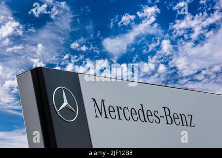 AUGSBURG, ALLEMAGNE – 16 JUIN 2022 : signe publicitaire de la marque Mercedes en face d'un ciel avec des nuages Banque D'Images