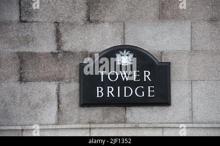 La plaque signalétique sur le mur en pierre de Tower Bridge. Banque D'Images