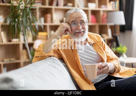 Homme âgé détendu prenant le café du matin à la maison Banque D'Images