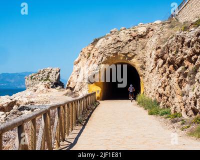 Les randonneurs et les cyclistes utilisent le sentier côtier le long de la côte de Malaga pour faire du sport à travers ses tunnels en face de la mer. Banque D'Images