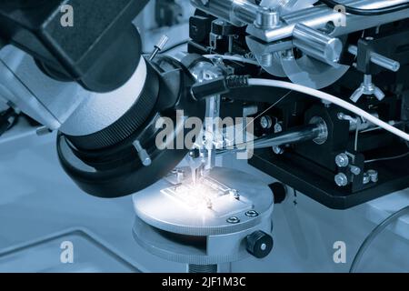 Équipement de test des copeaux. Fabrication de micropuces. Une étude en gros plan d'un échantillon de test d'une puce de transistor sous microscope en laboratoire. Auto Banque D'Images