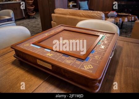 Seattle, WA USA - vers novembre 2021 : vue d'un tableau de monopole de fantaisie sur une table en bois à l'intérieur d'une salle de jeux d'un hôtel. Banque D'Images