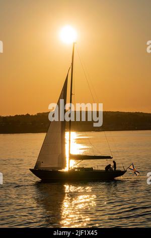Voilier silhoueté contre un lever de soleil à Halifax, Nouvelle-Écosse, Canada. Banque D'Images