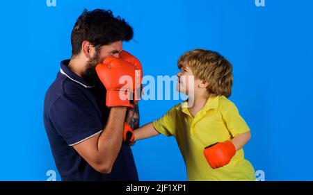 Enfant en gants de boxe avec entraîneur. Activité de l'enfance. Formateur enseignant aux enfants comment effectuer des pointages. Banque D'Images