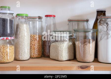 Étagère de cuisine avec jarres en verre plein de nourriture séchée. Conservation écologique des aliments. Banque D'Images