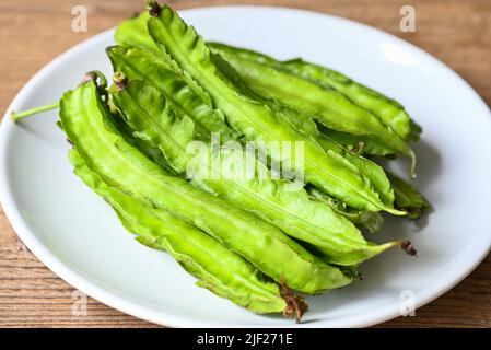 Haricot ailé sur fond de plaque blanche, Psophocarpus tétragonolobus - haricots verts aidés ou quatre angles Banque D'Images