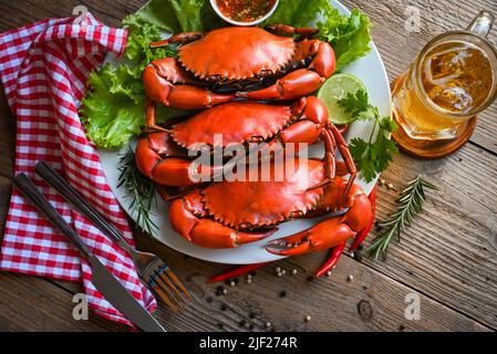 assiette de fruits de mer aux herbes épices romarin citron citron lime salade salade légumes, crabe frais sur plaque blanche sauce de fruits de mer et tasse verre à bière, cuisson au crabe Banque D'Images