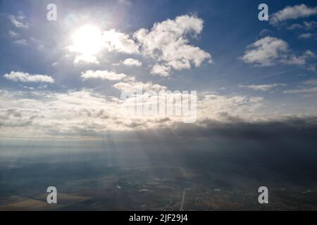 Vue aérienne depuis la haute altitude de la ville éloignée couverte de cumulus bouffieux qui se forment avant la pluie en soirée.Point de vue de l'avion du ciel nuageux Banque D'Images