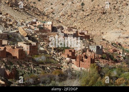 Village en brique de mudbrick dans les montagnes du Haut Atlas avec des arbres en premier plan Banque D'Images