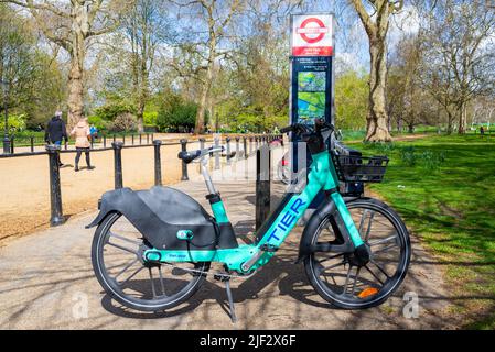 Tier Mobility vélo électrique à louer, garé par une station d'accueil de Santander cycles sur le bord de Hyde Park, Londres, Royaume-Uni. E Location de vélos Banque D'Images