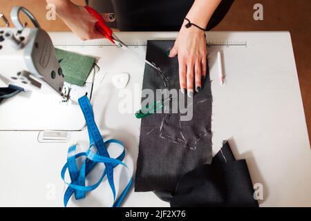 La couturière coupe le détail de la robe sur l'esquisse Banque D'Images