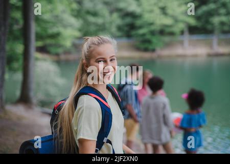 Jeune femme avec des amis lors d'un voyage de randonnée ou de camping en montagne en été. Banque D'Images