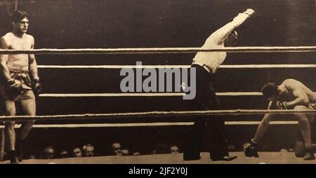 Championnat du monde de boxe 1930 - Phil Scott est compté pour avoir été battu par Stribling. Le 28th juillet 1930, le boxeur américain de poids lourd Young Stribling ( William Lawrence 'Strib' Stribling Jr. (1904 – 1933) a renversé le poids lourd britannique Phil Scott (Philip Scott Suffling ( 1900 -1983) au stade de Wimbledon devant une foule de 45 000 spectateurs. Stribling est décédé à l'âge de 28 ans à la suite d'un accident de moto. Banque D'Images