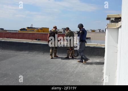 Non exclusif: KHARKIV, UKRAINE - 26 JUIN 2022 - des fonctionnaires se tiennent sur le toit d'un immeuble d'appartements pendant qu'ils enquêtent sur les conséquences du Rus Banque D'Images