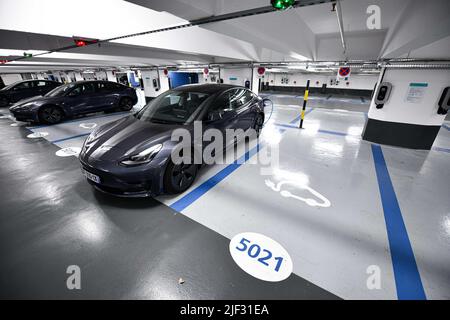 Parking sous l'église de la Madeleine, avec des voitures Tesla branchées pour être rechargées à Paris, France, sur 24 avril 2022. Un demi-millier de postes de charge pour voitures électriques sont maintenant opérationnels dans le parking Madeleine-Tronchet. Photo de Victor Joly/ABACAPRESS.COM Banque D'Images