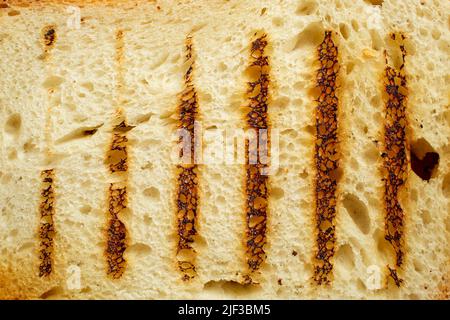 lignes verticales sur une tranche de pain. Fond de texture de toast grillé Banque D'Images