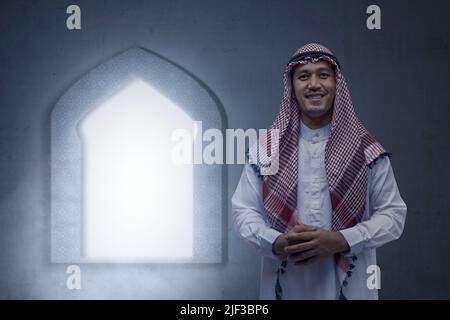 Homme arabe portant du keffiyeh debout à l'intérieur de la mosquée Banque D'Images