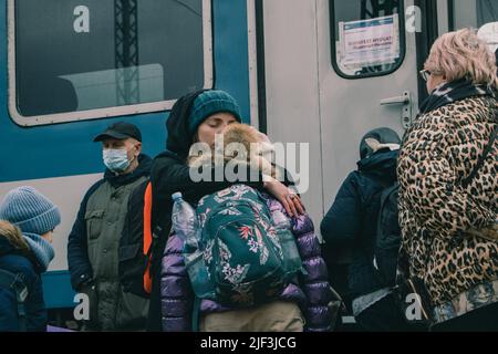 Mère embrasse son fils jusqu'à ce qu'elle puisse entrer dans le train. La gare de Záhony est le principal point d'accès de la Hongrie pour des milliers de réfugiés fuyant l'invasion russe. Banque D'Images