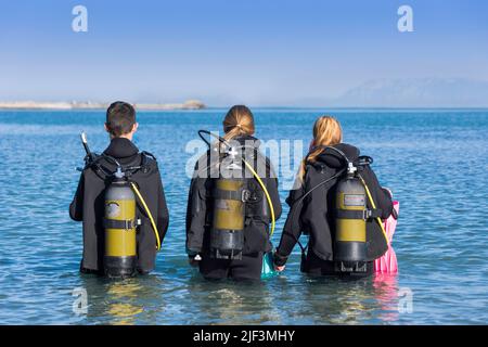 Plongée sous-marine plongeurs marchant dans la mer sur une rive plongée de l'arrière Banque D'Images