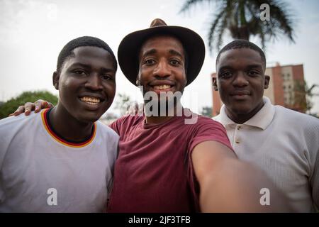 Trois jeunes amis prennent un selfie et sont souriants et heureux, les gars africains Banque D'Images