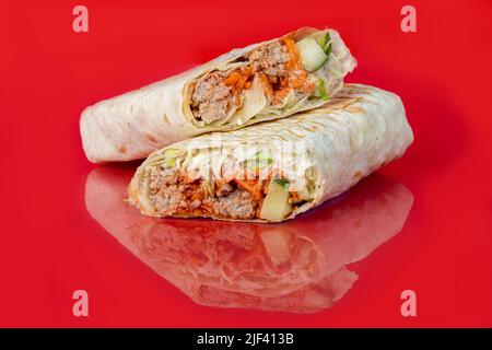 Rouleau de poulet avec légumes. Chou frais, concombres, carottes et légumes verts. Sur un arrière-plan coloré. Shawarma. Copier l'espace Banque D'Images