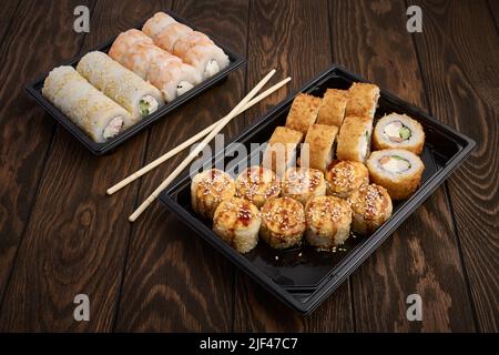 Cuisine orientale, petits pains dans des plateaux à emporter en plastique sur une table en bois Banque D'Images