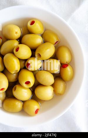 Olives vertes marinées avec poivrons de Pimento dans un bol, vue du dessus. Pose à plat, en hauteur, par le dessus. Banque D'Images